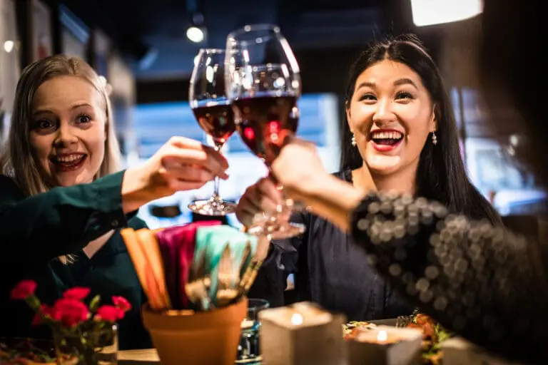 Iloiset ravintola-asiakkaat kohottavat maljaa ravintolassa.