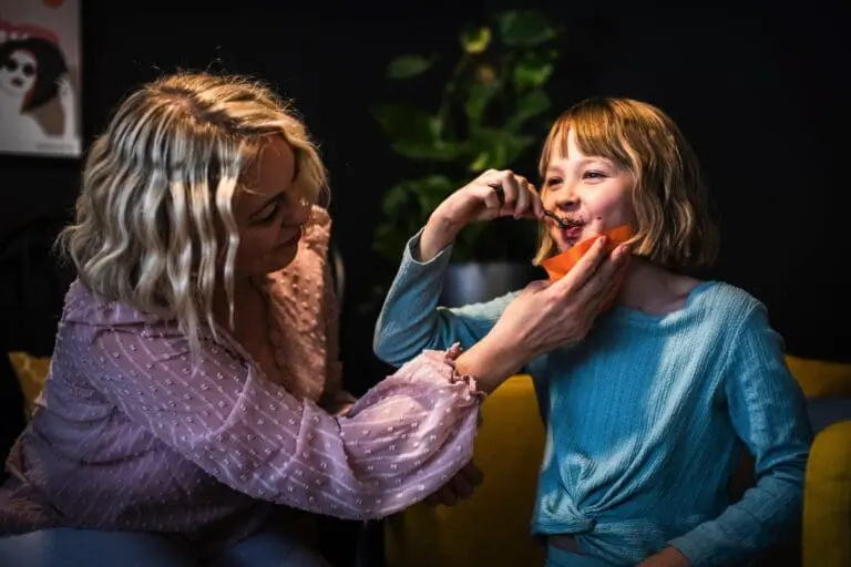 Äiti pyyhii lapsensa kasvoja ravintolassa Softlin-liinalla.